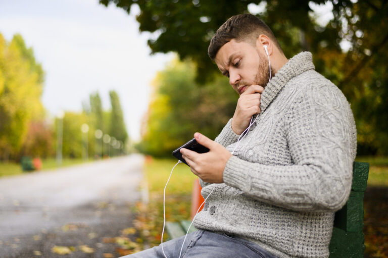 stressed-man-with-smartphone-headset-bench (1)